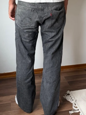 Levis 505 W32 L32 - Säljer ett par grå jeans med rak passform och klassiska fem fickor. Jeansen har en snygg vintage-tvätt och kontrastsömmar. Passar perfekt till en avslappnad stil och har en diskret röd detalj vid bakfickan.