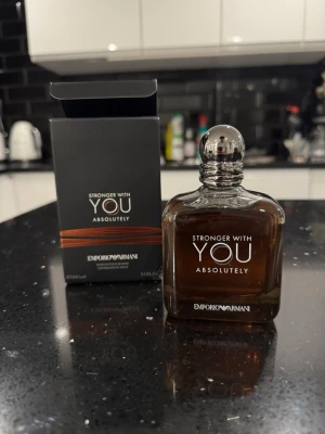  Armani Stronger With You absolutely  - Emporio Armani Stronger With You Absolutely är en elegant parfym i en mörkbrun glasflaska med rundad form och silverfärgad kork. Flaskan har en stilren design och levereras med originalkartong. Perfekt för dig som gillar exklusiva dofter.