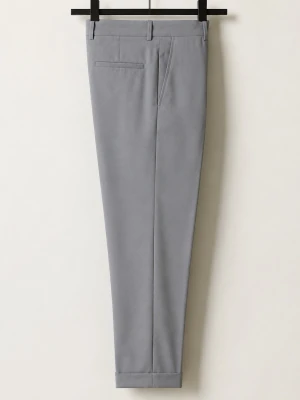 Grå kostymbyxa Likande till Filippa K Terry Cropped Trousers.  - Snygg grå trousers med slim passform och pressveck. Filippa K Terry Cropped Trousers.  Byxan har bälteshällor, snedställda fickor fram och en passpoalficka bak. Materialet är slätt och ser ut att vara av polyesterblandning, perfekt för en clean och stilren look. Väskan följer med 