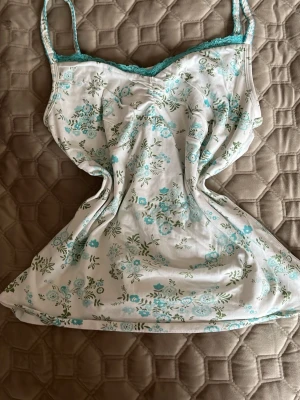 Sött linne - Vitt linne med blå/gröna blommor på. Liten blå spets längs bröstet