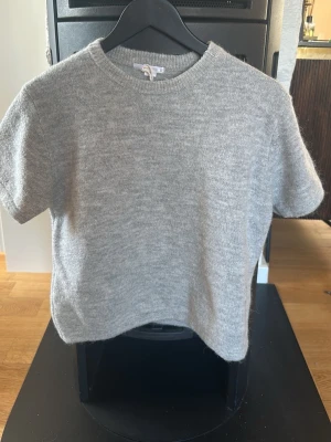 Kortärmad tröja Gina Tricot - Kortärmad stickad tröja från Gina Tricot. Knappt använd. Grå.