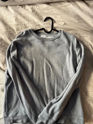 Grå sweatshirt från Fruit of the Loom - En basic grå sweatshirt från Filippa K med rund halsringning och långa ärmar. Tillverkad i mjukt material. 