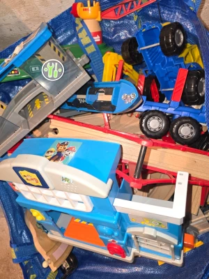Stort paket med leksaksfordon och banor - Säljer ett blandat paket med leksaksfordon, byggdelar och banor. Innehåller bland annat blå lastbil, delar från Paw Patrol och olika plast- och trädelar till bilbanor. Perfekt för dig som gillar att bygga och leka med bilar och fordon.