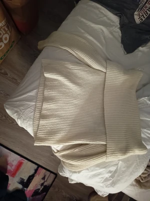 Krämvit ribbstickad polotröja - Säljer en krämvit ribbstickad polotröja med långa ärmar och bred polokrage. Tröjan har en avslappnad passform och är tillverkad i ett mjukt, tjockare material som känns riktigt cozy. Perfekt för lager-på-lager och snygg till jeans eller kjol.