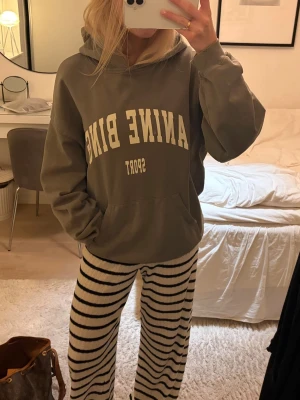 Grå hoodie från Anine Bing Sport - Säljer en oversized grå hoodie från Anine Bing Sport med stor vit text framtill. Hoodien har huva, känguruficka och ribbade muddar vid ärmslut och nederkant. Den är i storlek XXS men passar mycket döttrar med. Jag brukar ha XS o den är oversize på mig