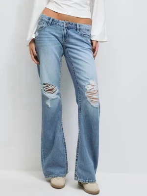 Ljusblå slitna bootcut jeans - Säljer ett par ljusblå bootcut jeans med slitningar och hål på båda benen framtill från ginatricot. Jeansen har klassisk femficksmodell, låg midja och är tillverkade i denim. De är inprincip helt nya, endast använda 1 gång så i superfint skick! Helt slutsålda på Ginatricots hemsida. Perfekta för en avslappnad och trendig look. 