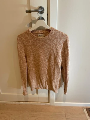 Beige melerad stickad tröja - Säljer en beige melerad stickad tröja från Day Birger et Mikkelsen. Tröjan har rund halsringning, långa ärmar och en avslappnad passform. Perfekt för lager på lager och enkel att matcha med jeans eller kjol.