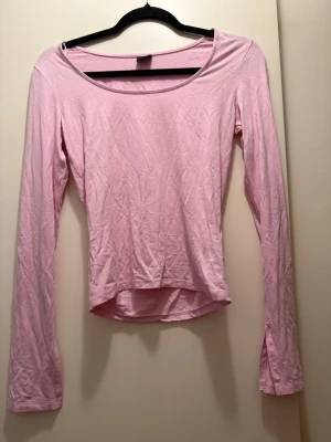 Ljusrosa långärmad topp från gina tricot - Söt ljusrosa långärmad topp med rundad halsringning och något croppad passform. Tillverkad i mjukt bomullsmaterial som känns skönt mot huden. Perfekt att styla med jeans eller kjol för en enkel och fräsch look.