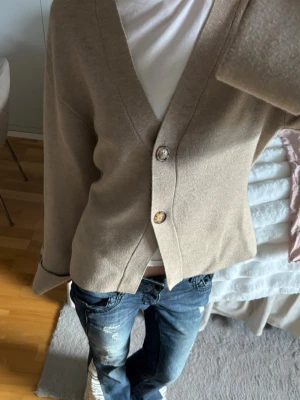 Beige kofta med stora knappar - En stilren beige kofta. Jättefint skick och endast använd en gång.