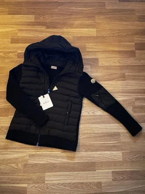 Svart moncler cardigan - Hej, säljer en fräsch moncler cardigan i svart som är perfekt nu inför våren😊 Skriv gärna om ni har några funderingar!