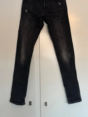 Jack And Jones jeans med slitningar - Säljer ett par Jack And Jones jeans med slitningar. Modellen är slim/glenn i storlek 30/34. Den är i jättebra skick och riktigt snygga! Bud tas emot.