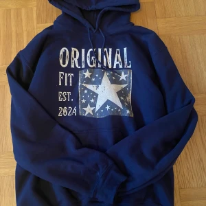 Mörkblå hoodie med stjärntryck - Riktigt skön och snygg hoodie! Den är väldigt varm och sitter väldigt bra. Skönt material och ett väldigt snyggt tryck på framsidan av tröjan, storlek S, nypris 700!⭐️