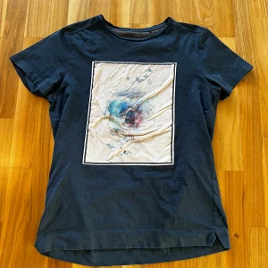 Limitato T-shirt  - Jag säljer en snygg limitato T-shirt med ett coolt tryck på magen. T-shirten är i ett bra skick och nypris ligger på 1,7k. T-shirten är i storlek M och passar mig som är 170 cm