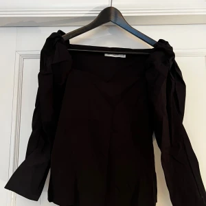 Svart tröja  - Snygg svart tröja från Carin Wester med v-ringning och långa puffärmar. Knappt använd 