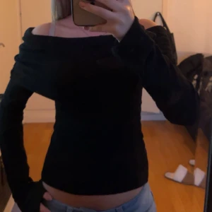 Svart offshoulder topp - Snygg svart offshoulder topp med långa ärmar. I storlek xs. Använd 1 gång så i nytt skick!! Inga slitningar