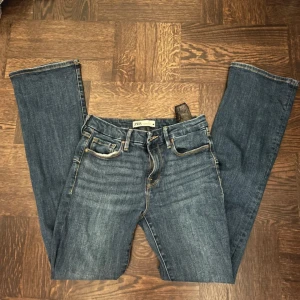 Blå jeans från Zara - Snygga blå jeans från Zara med klassisk femficksdesign och knappgylf. Perfekta för en avslappnad stil. Booth-cut/ utsvängda trendiga jeans 