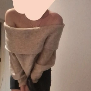 Beige offshoulder tröja - Säljer en mysig beige offshoulder tröja. Den är stickad och har en lös passform som ger en avslappnad look. Perfekt för kyliga dagar när du vill känna dig både bekväm och stilren.