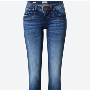 Blå jeans med slitningar - Snygga blå jeans med lätt slitna detaljer och klassisk femficksdesign. De har en knapp och dragkedja framtill samt kontrastsömmar som ger en cool look.