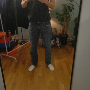 Blå jeans från H&M - Säljer ett par klassiska blå jeans från H&M i straight regular fit. Perfekta för en avslappnad stil med fem fickor och knappgylf.