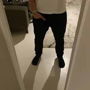 Svarta jeans från weekday - Snygga svarta jeans med slim passform. Perfekta för en stilren look. Jeansen har en klassisk design med knappar och dragkedja. W32 L30 men dom sitter mellan L 30 L 32. Jag har vanligt vis L32 i jeans och dom sitter som 32 men bara pytte lite mindre. Passar både till L32 och L30 personer. Jeansen är använde runt 3 gånger så är som i nytt skick. Kolla min profil för billiga bra deals för jeans och piké tröjor🔥🔥🔥. Hör av er med minsta fundering👍