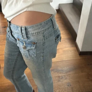 Ljusblå low waist jeans från Angels✨✨ - Snygga ljusblå jeans från Angels med en klassisk femficksdesign och knappdetaljer. De har en straight/bootcut passform och är perfekta för en avslappnad stil. Jeansen har en lätt tvättad look som ger dem en cool vintagekänsla✨💗💗 de är väldigt lågmidjade o snygga🫶passar för för en längd på 150/155 cm. Midjemått rakt över: 38 cm. Innerbenslängd: 64 cm🌸