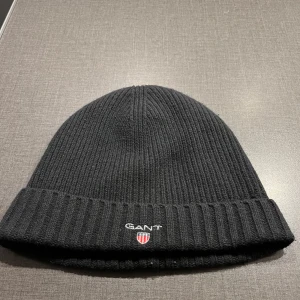 Gant mössa - Säljer denna fina gant mössa. Den är tjock och passar perfekt till det kalla vädret. Den är i väldigt bra skick då den inte är använd så mycket.
