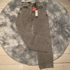 Grå baggy jeans från FSBN - Säljer ett par grå baggy jeans från FSBN. De har en avslappnad passform och är perfekta för en casual look. Jeansen har klassiska fem fickor och en dragkedja. Märket FSBN är känt för sin stilrena design.