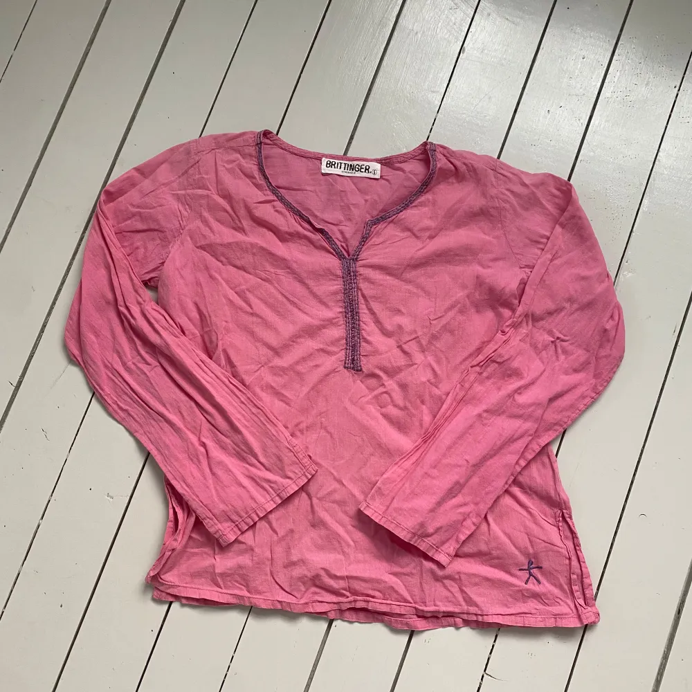 Säljer en söt rosa blus från Brittinger i storlek S. Blusen har långa ärmar och en v-ringad hals med dekorativa sömmar. Perfekt för en avslappnad stil.. Yläosat.