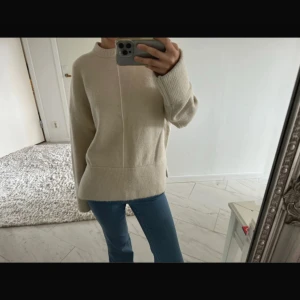 Zara stickad tröja - Säljer en mysig beige stickad tröja med långa ärmar och ribbade detaljer vid ärmslut och nederkant. 