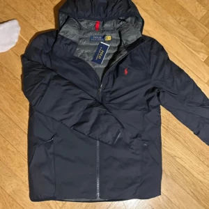 Ralph lauren jacka(HELT NY) - Tja, ja säljer nu denna helt nya Ralph lauren jackan med prislapp kvar. Nyrpis är 4295 mitt pris 1599. Den är givetvis äkta och storlek M. Jackan är varmt fodrad med polyester o den går att packa ihop till en smidig påse vilket syns på sista bi of en. Tryck gärna på köp nu och hör av er vid funderingar. Allt gott// Armadio💫
