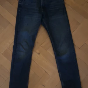 Tommy Hilfiger Jeans - Snygga mörkblå jeans från Tommy Hilfiger med klassisk design utan skador eller liknande. De har en rak passform och är tillverkade i slitstarkt denim. Perfekta för en stilren look. Storlek W30 L32