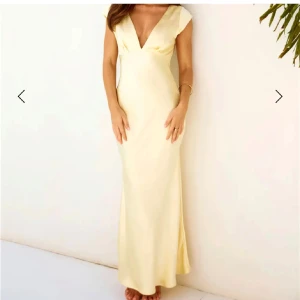 Ljusgul långklänning med öppen rygg - Säljer denna supersnygga och slutsålda satinklänning! Nypris 1800kr då det var tull på den. Helt oanvänd! Säljer då jag har en annan balklänning🥰