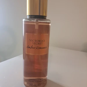 Amber Romance Mist från Victoria's Secret - En förförisk doftmist från Victoria's Secret med namnet Amber Romance. Flaskan är elegant med en gyllene kork och rymmer 250 ml. Doften har inslag av djup amber och sötma, perfekt för att fånga solnedgångens magi.
