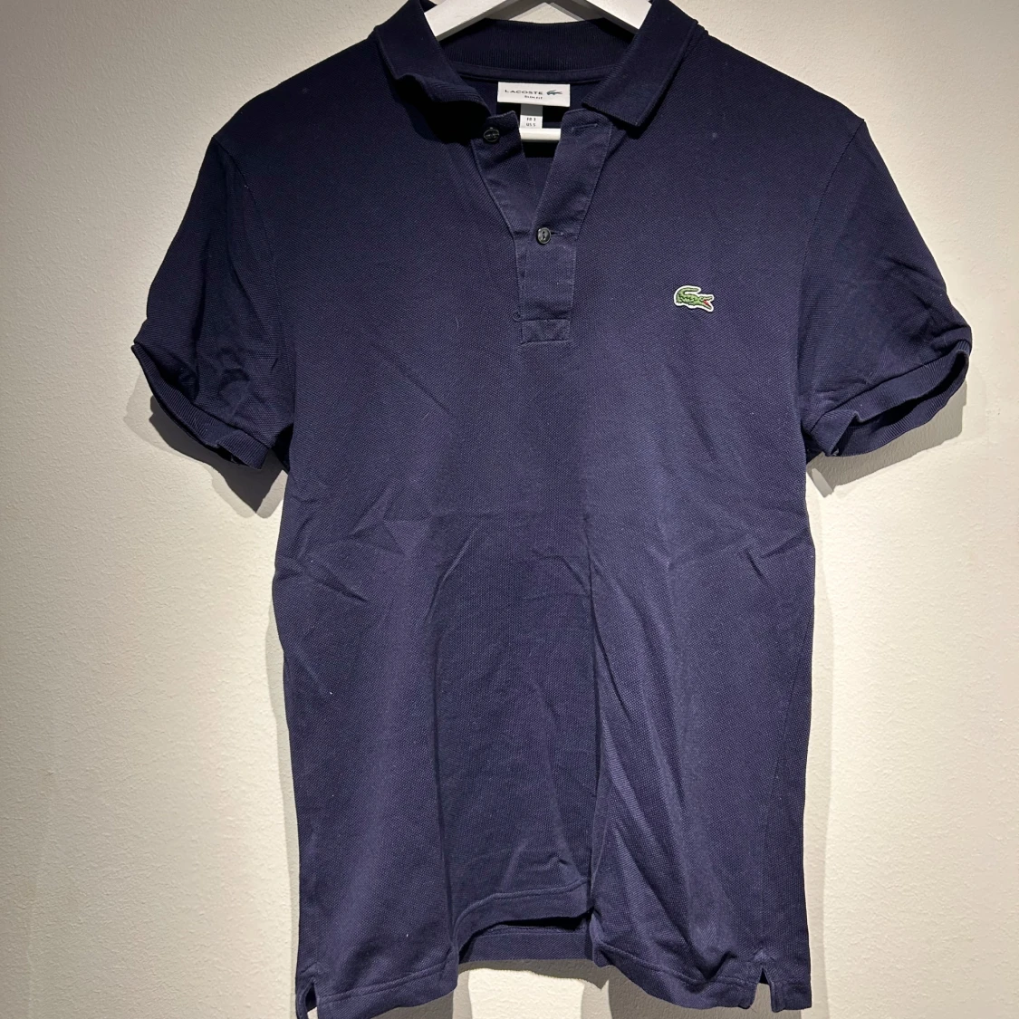 Mörkblå pikétröja från Lacoste