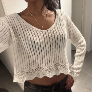Vit stickad croppad tröja - Säljer en vit stickad tröja med v-ringning och långa ärmar. Tröjan är croppad med ett fint mönster längst ner. Perfekt för en stilren och avslappnad look❤️❤️❤️