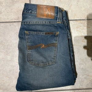 Nudie Jeans - Säljer ett par blå jeans från Nudie. De har en slim/ något straight passform. Skicket är extremt bra, i stort sätt som nya. Mitt pris 550, skriv vid frågor eller funderingar!👍