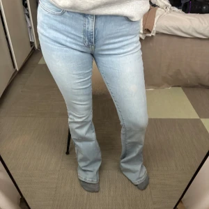 Ljusblå bootcut jeans - Snygga ljusblå bootcut jeans med låg midja. De har en klassisk femficksdesign och en fransig kant vid bensluten för en trendig look. Perfekta för en avslappnad stil. Slitna i hälen då jag är 160
