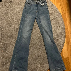 Blå bootcut jeans - Snygga blå bootcut jeans med klassisk femficksdesign. Perfekta för en avslappnad stil. De har en bekväm passform och är tillverkade i ett slitstarkt material.