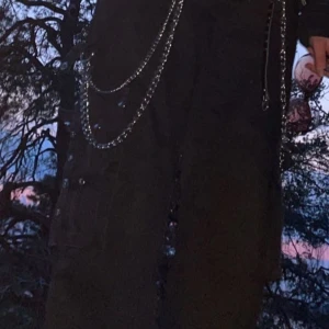 Svarta cargopants med kedjor - Snygga svarta cargopants med coola kedjedetaljer och lila sömmar. Köpta på bluefox 