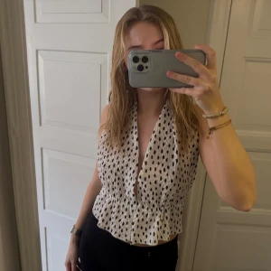 Söt topp med öppen rygg - Jättefin topp med öppen rygg i prickigt mönster. Man knyter där bak. Använd fåtal gånger. Kommer inte till användning