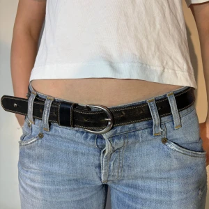 Svart skärp med nitar - Snyggt svart skärp med silverfärgade nitar och en klassisk spänne. Perfekt för att ge en edgy touch till din outfit. Passar bra till jeans och andra casual kläder. 💞