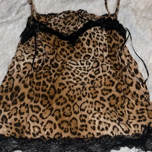 Leopardmönstrad linnetopp från Zara - Säljer en snygg leopardmönstrad linnetopp från Zara med svarta spetsdetaljer vid halsringning och nederkant. Perfekt för en trendig look. 🐆