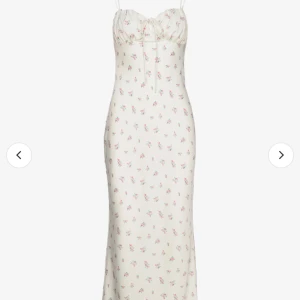 Somrig vit klänning med rosa blommor - Somrig vit silkes klänning från Gina Tricot med små söta blommor på! Använd ett fåtal gånger men kommer inte längre till användning! Väldigt tjockt och fint material som gör en jättefin passform!