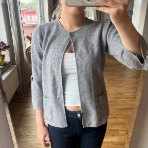 Trekvartsärmad kofta - Trekvartsärmad kofta med rosetter på ärmarna. Knäpps med en knapp. Så fin till hösten!! Skicket är mycket bra🩷