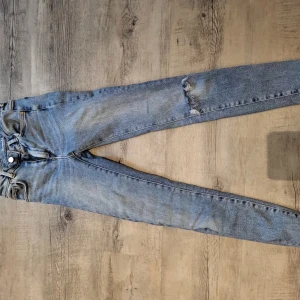 Jeans från Bikbok - Blåa skinny jeans från Bik Bok. Högmidjade med en del strech. En skada på ena knät men kan ses som en fin detalj. 