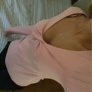 Rosa långärmad topp - Säljer en söt rosa långärmad topp med en snygg drapering framtill. Toppen har en djup v-ringning och är perfekt för både vardag och fest. Den är i ett mjukt och bekvämt material. Använd ungefär 2 gånger💕