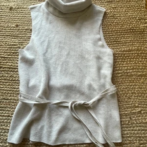Beige zara topp utan armar med knytningar  - En jättegullig topp utan ärmar från zara i storlek S. Den är i ett mjukt material och har inga defekter då den aldrig är använd. Säljer pga att den helt enkelt aldrig blivit andvänd💗💗