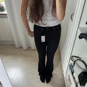 Svarta jeans från 157 - Säljer ett par snygga svarta jeans från 157 i modellen Snake Flare. Perfekta för både vardag och fest! Helt nya aldrig använda!
