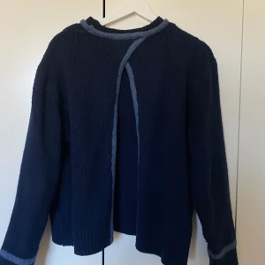 Marinblå Zara tjocktröja - En superfin poppis tjocktröja från Zara i marinblått med ränder i ljusare blå vid hals och ärmar. Jättesnygg detalj med bar rygg!