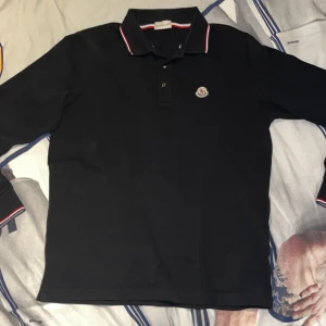 Moncler långärmad piké - Säljer denna helt galna Moncler pikén i storlek M, passar S också. Skick 9/10 nästan som en ny. En av dom fetaste plaggen just nu🔥
